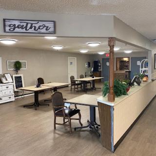 A spacious gathering area featuring tables and chairs, designed for collaboration and community interaction.