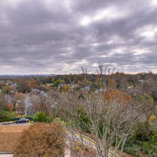 Overcast sky above a suburban landscape with autumn foliage.