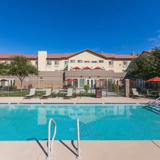 Outdoor swimming pool area at a hotel on a sunny day.