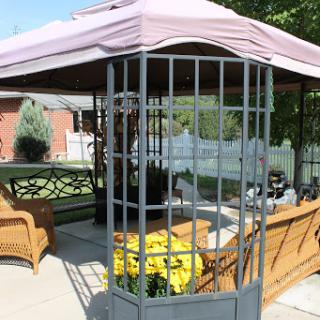 A cozy gazebo in a garden setting, perfect for relaxing and enjoying the outdoors.
