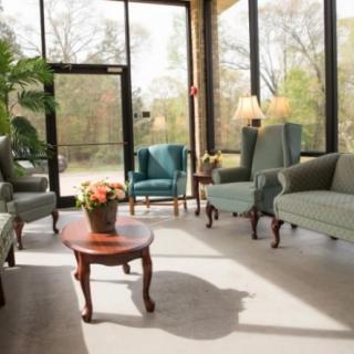 A well-lit waiting room with comfortable seating and large windows.