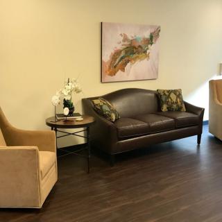 A cozy waiting room with a sofa, chairs, and elegant decor.