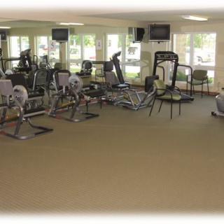 A spacious gym area equipped with various exercise machines and fitness equipment.