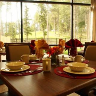 A beautifully set dining table with a scenic view through large windows.