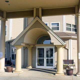 A building entrance with large columns and an arched awning.