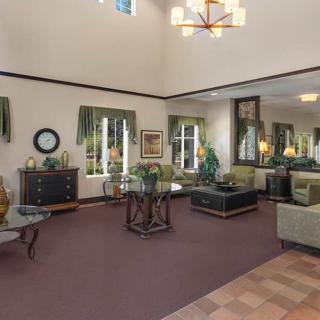 A spacious and elegantly decorated living room with comfortable seating and a high ceiling.