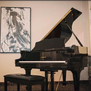 A grand piano in a music room with abstract artwork on the wall.