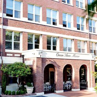 A historic brick building with an inviting entrance, likely serving as a hotel.