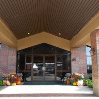The welcoming entrance of a hotel adorned with colorful flowers and a spacious canopy.