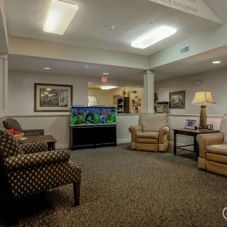 A cozy waiting room with comfortable seating and a large fish tank.