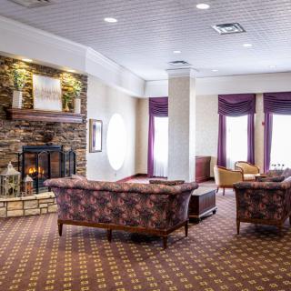 A cozy lounge area with sofas, armchairs, and a fireplace.