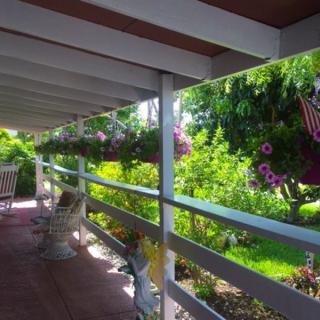 A tranquil veranda overlooking a lush garden with blooming flowers.