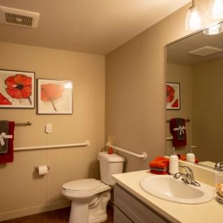 Modern bathroom with artwork and warm lighting.