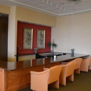 A well-appointed conference room with a long meeting table and several chairs, featuring elegant artwork on the walls.