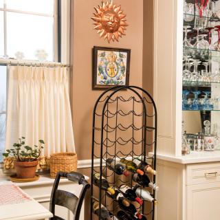 A cozy kitchen corner featuring a wine rack, potted plants, and decorative wall art.
