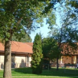 A scenic view of a building surrounded by lush green trees and grass.