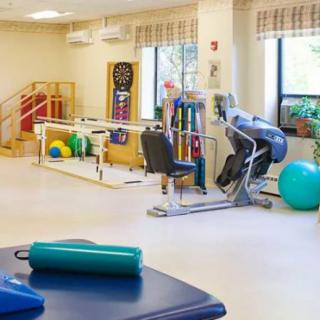 A well-equipped physical therapy and rehabilitation room with various exercise machines and equipment.