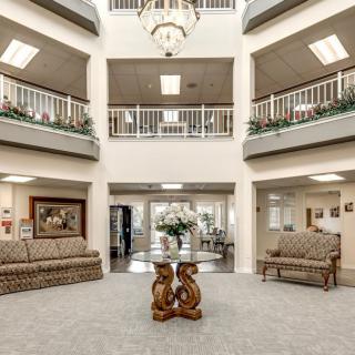 Spacious lobby area with comfortable seating and a central chandelier.