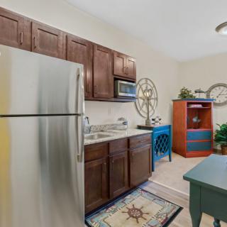 A cozy kitchen with wooden cabinets, stainless steel appliances, and decorative accents.