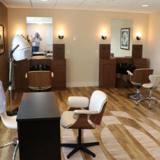 A modern hair salon interior with styling chairs and mirrors.