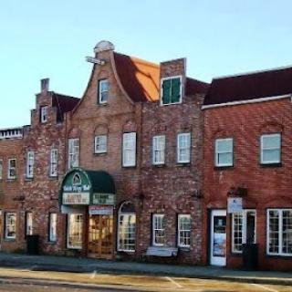 A charming brick building featuring a mix of architectural styles, likely housing shops or businesses.