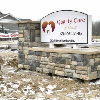 A sign for Quality Care Senior Living located in a snowy outdoor setting.