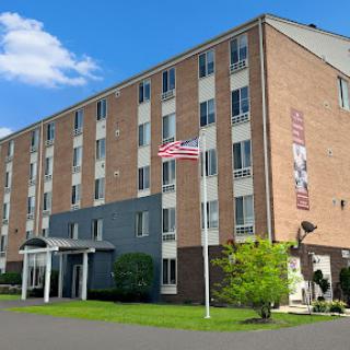 A well-maintained hotel building with a flag in front, showcasing a welcoming exterior.