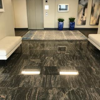 A stylish and modern lobby featuring sleek seating, a polished marble floor, and decorative elements.
