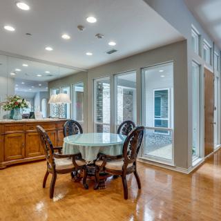 A modern dining area with elegant furniture and large windows.