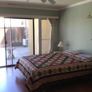 A cozy bedroom with a quilt-covered bed and sliding glass door.