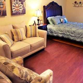 A cozy bedroom with a sofa and a bed, featuring warm lighting and decorative elements.