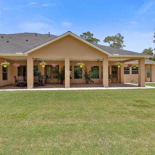 A suburban house with a large patio and manicured lawn.