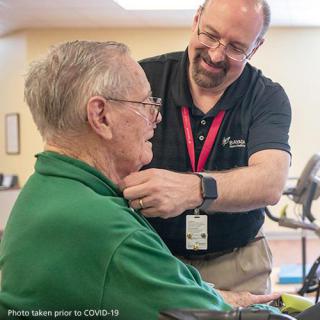 A caregiver assists an elderly man, highlighting the importance of support and companionship in healthcare.