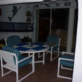 An outdoor patio area with chairs and a table in the evening.