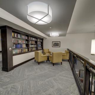 A cozy library corner with bookshelves and comfortable seating.
