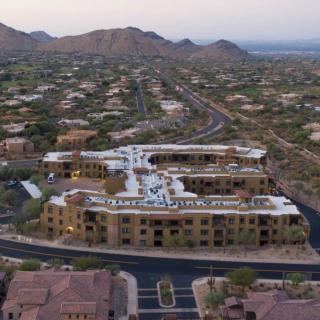 Aerial view of a residential area surrounded by desert and mountains.