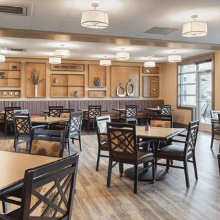 A spacious and modern dining room with neatly arranged tables and chairs.