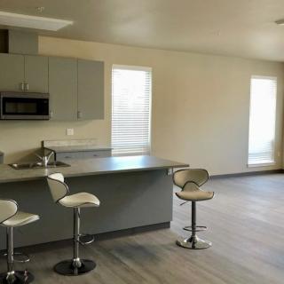A modern, minimalist kitchen with an island and bar stools.