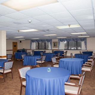 A spacious dining area set up with blue tablecloths and chairs, ready for an event.