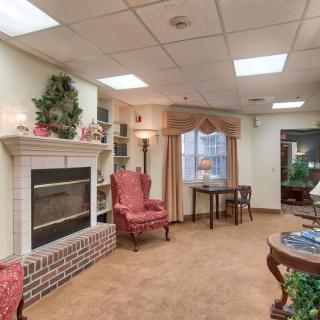 A cozy living room featuring a fireplace, armchair, and elegant decor.