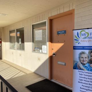 Entrance to a facility with signage and a banner outside.