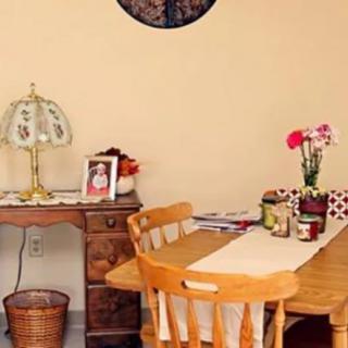 A cozy dining area featuring a wooden table with chairs, adorned with a vase of flowers and decorative items.