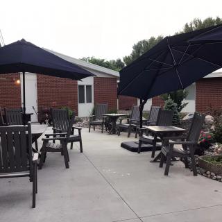 A cozy patio with outdoor seating, featuring tables and chairs under large umbrellas.
