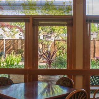 A cozy indoor dining area with a view of a lush garden through large windows.
