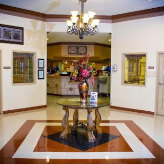 A welcoming hotel lobby featuring elegant decor and a vibrant floral arrangement.