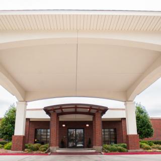 A view of a building entrance with a large canopy and brick facade.