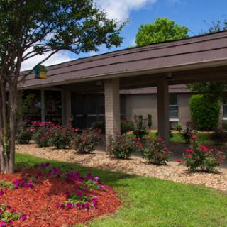 A well-maintained building surrounded by colorful flowers and lush greenery.