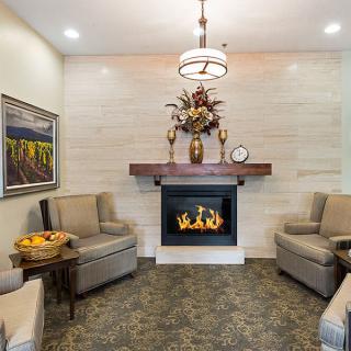 A cozy living room with a fireplace, comfortable armchairs, and elegant decor.