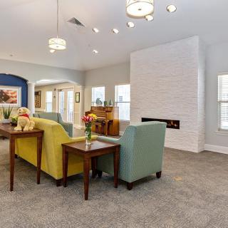 A modern living room featuring colorful sofas, a central fireplace, and elegant lighting.