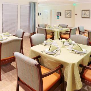 An elegantly set dining room with neatly arranged tables and chairs.